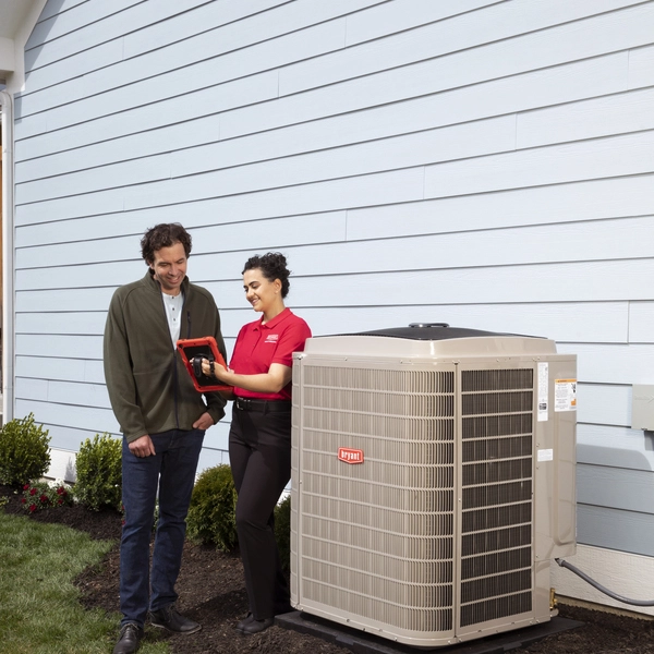 bryant tech talking with client outdoor in front of unit